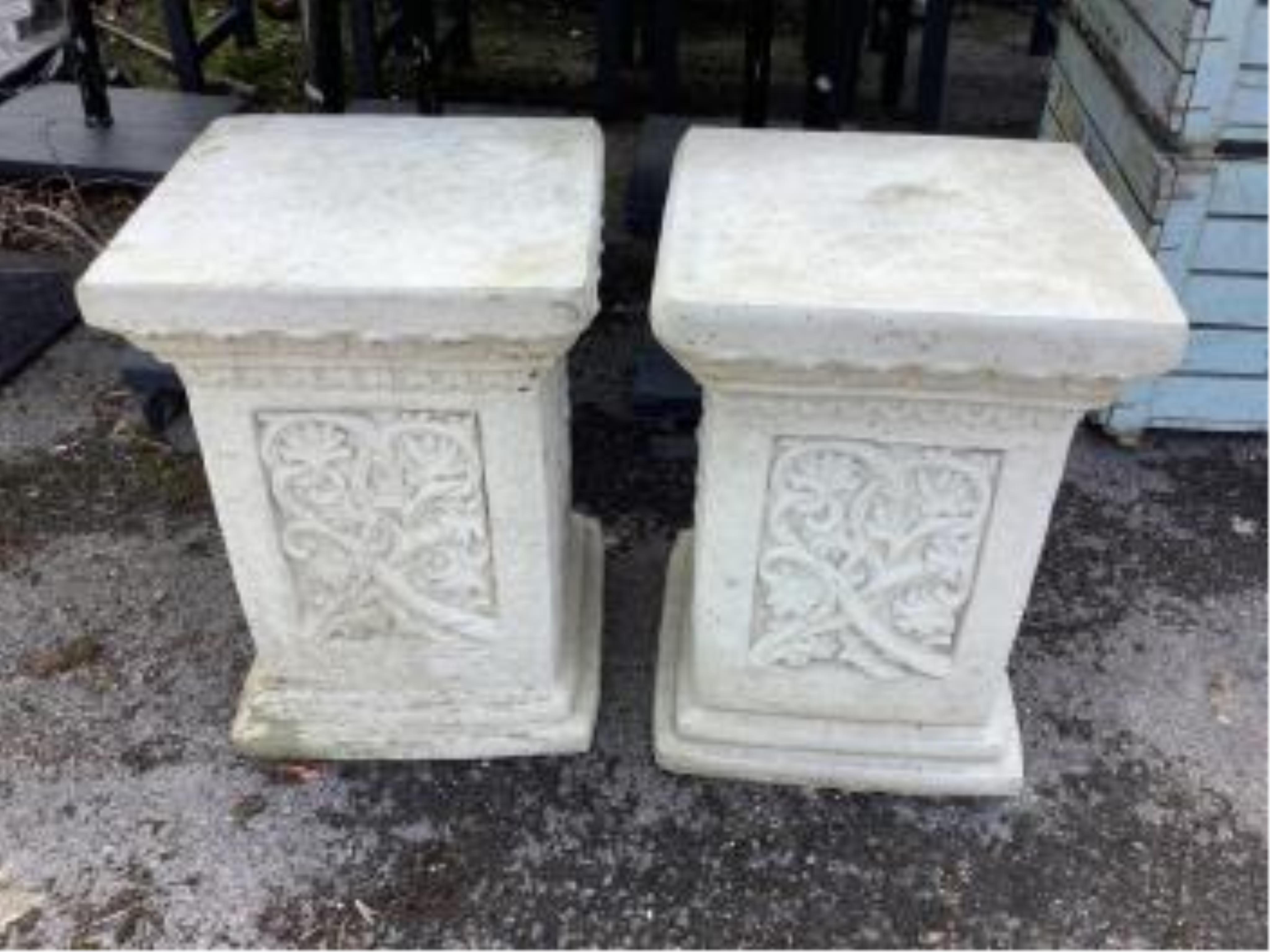 A pair of Sparta Statues reconstituted stone plinths, with scrolling foliate decoration, width 36cm, height 50cm. Condition - a little weathered, otherwise good